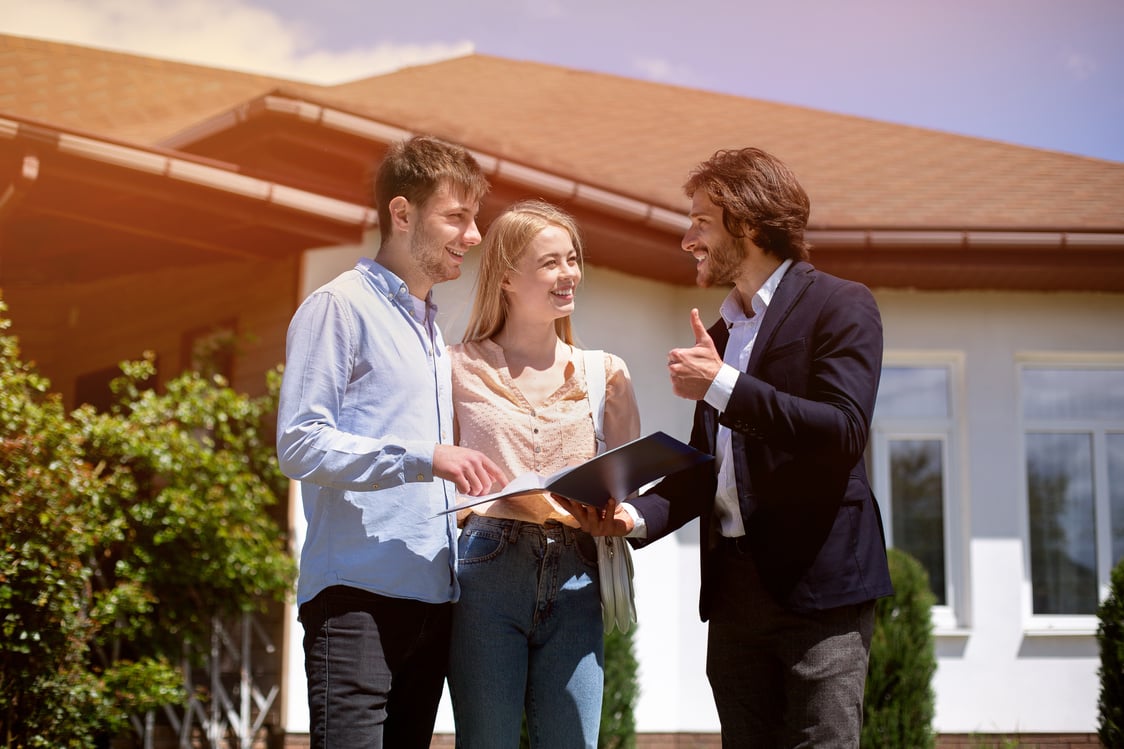 Property manager showing real estate purchase agreement to clients in house backyard